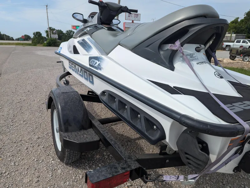 Slide: The Image of 2006 Sea-Doo GTX jet ski on trailer, parked on gravel road. - 4