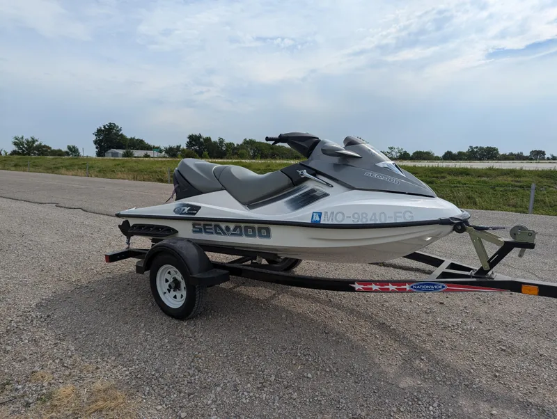 Slide: The Image of 2006 Sea-Doo GTX jet ski on trailer, parked on gravel road. - 9