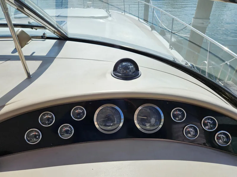 Slide: The Image of Dashboard of a 2002 Sea Ray 460 Sundancer yacht with gauges and compass. - 14