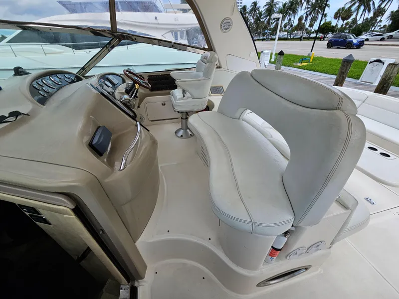 Slide: The Image of Interior view of 2002 Sea Ray 460 Sundancer yacht with white seating and helm. - 9