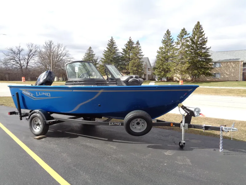 The Image of 2024 Lund 1650 Rebel XL Sport boat on trailer, parked outdoors. - 0