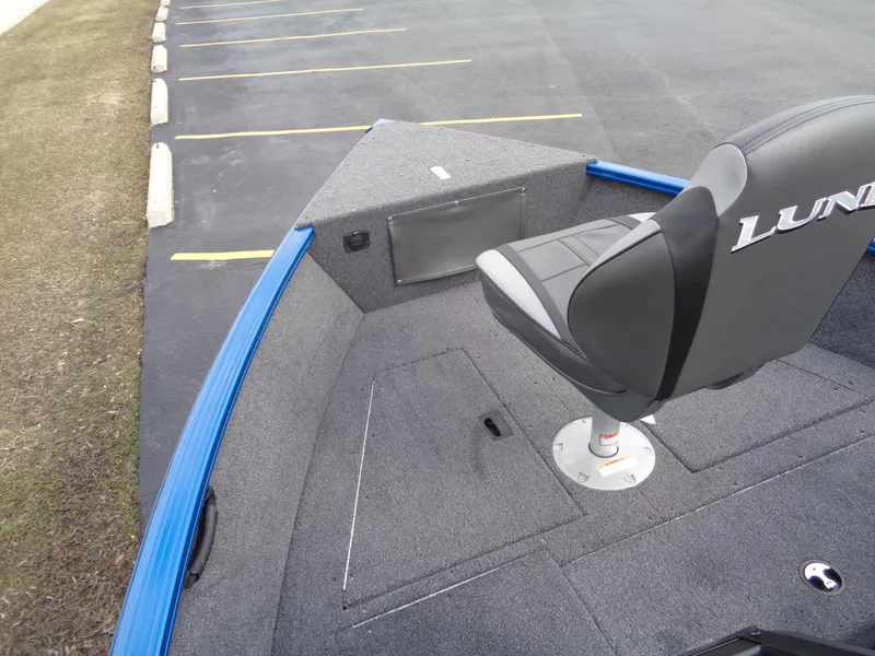 Slide: The Image of 2024 Lund 1650 Rebel XL Sport boat interior with seating and storage compartments. - 12