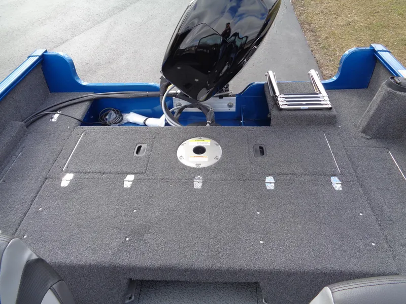 Slide: The Image of 2024 Lund 1650 Rebel XL Sport boat interior with motor and storage compartments. - 17