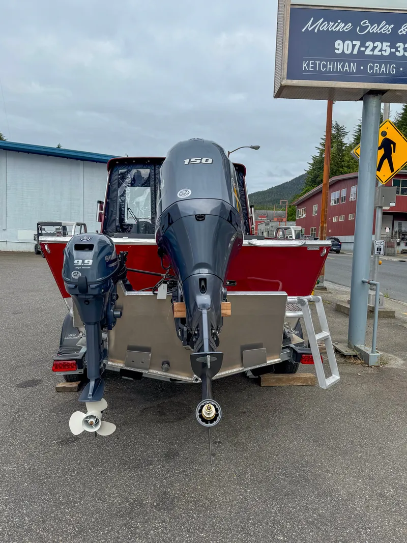 Slide: The Image of 2024 Hewescraft 200 ProV ET HT boat with dual outboard motors in a parking lot. - 2