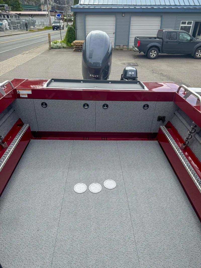 Slide: The Image of 2024 Hewescraft 200 ProV ET HT boat interior with motor, parked outdoors. - 8