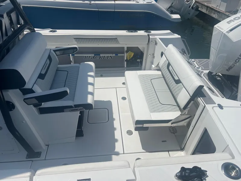 Slide: The Image of 2023 Blackfin 302 CC boat with twin outboard engines docked at a marina. - 10