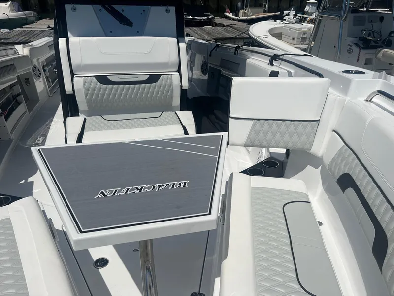 Slide: The Image of 2023 Blackfin 302 CC boat interior at marina, featuring spacious seating and modern design. - 30