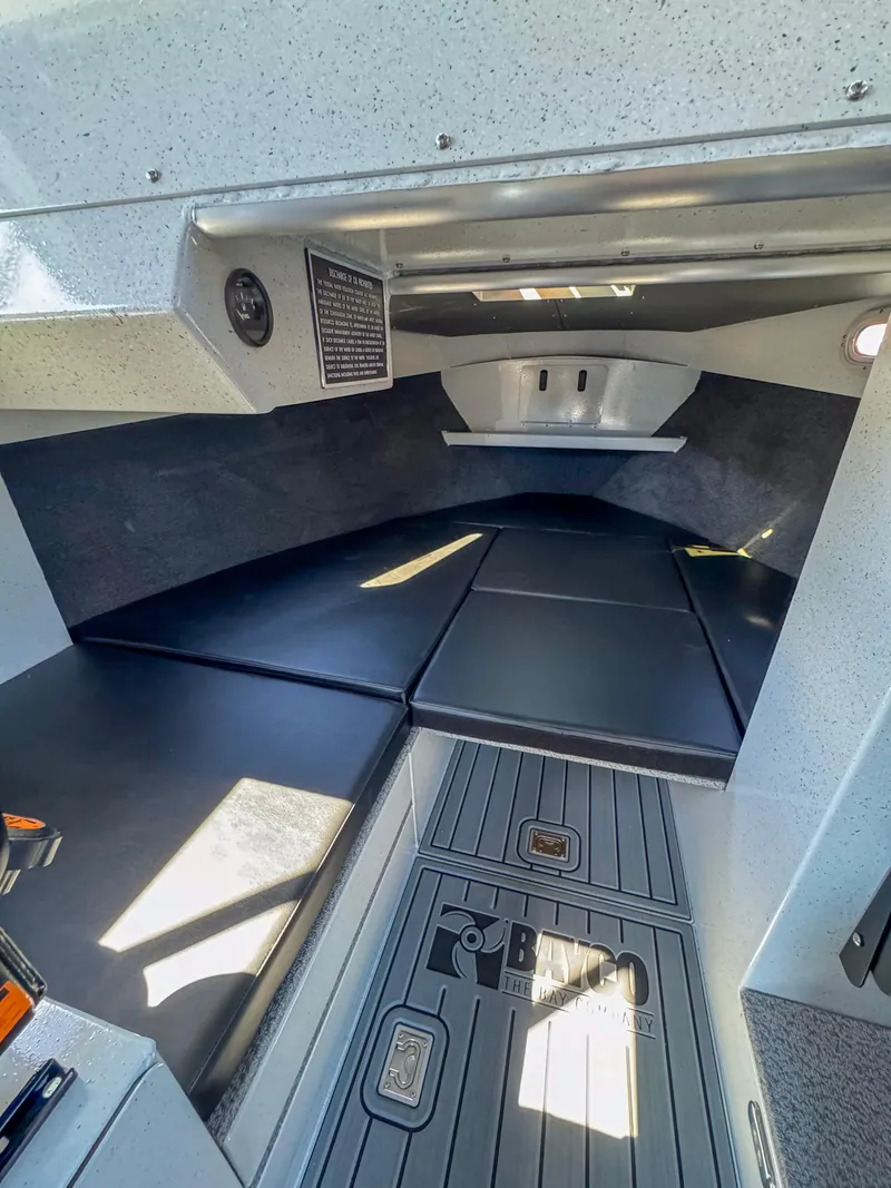 Slide: The Image of 2024 North River Seahawk OS 2700SXL cabin interior with cushioned seating and storage compartments. - 11