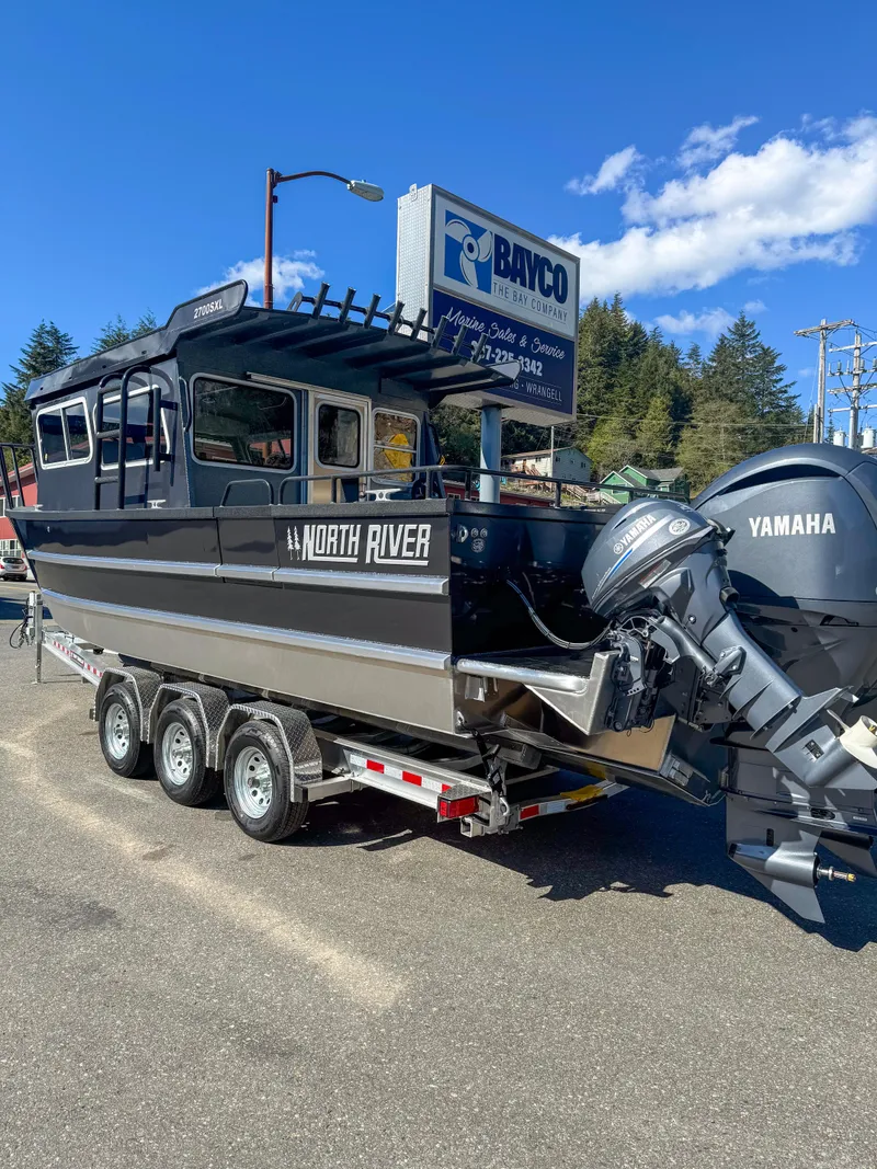Slide: The Image of 2024 North River Seahawk OS 2700SXL boat with Yamaha engines on a trailer. - 2