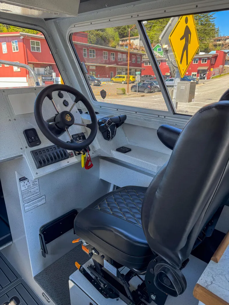 Slide: The Image of 2024 North River Seahawk OS 2700SXL boat interior with steering wheel and captain's chair. - 5