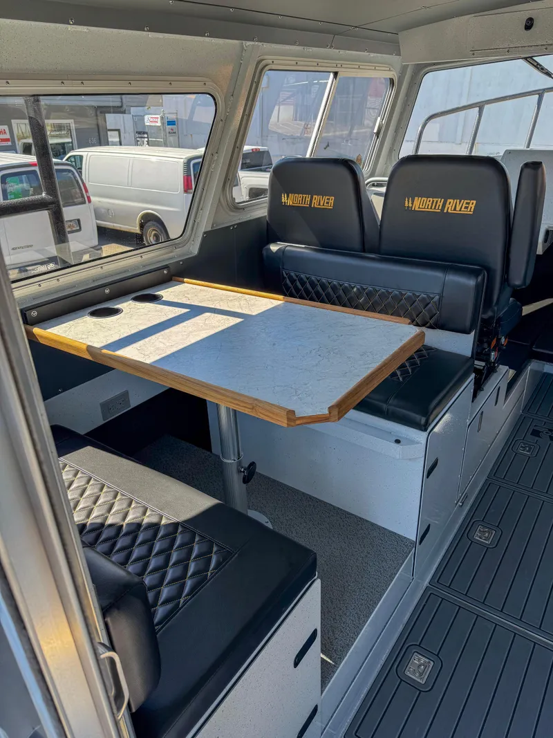 Slide: The Image of 2024 North River Seahawk OS 2700SXL boat interior with seating and table. - 7
