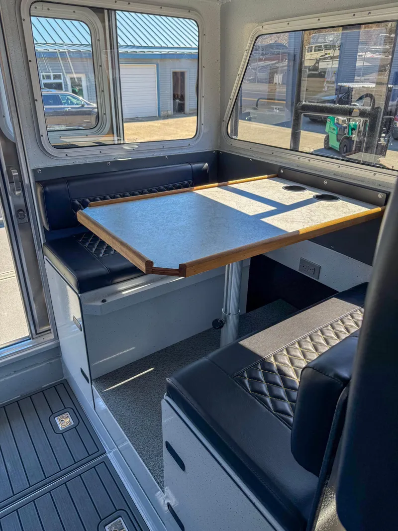 Slide: The Image of 2024 North River Seahawk OS 2700SXL interior dining area with table and seating. - 8