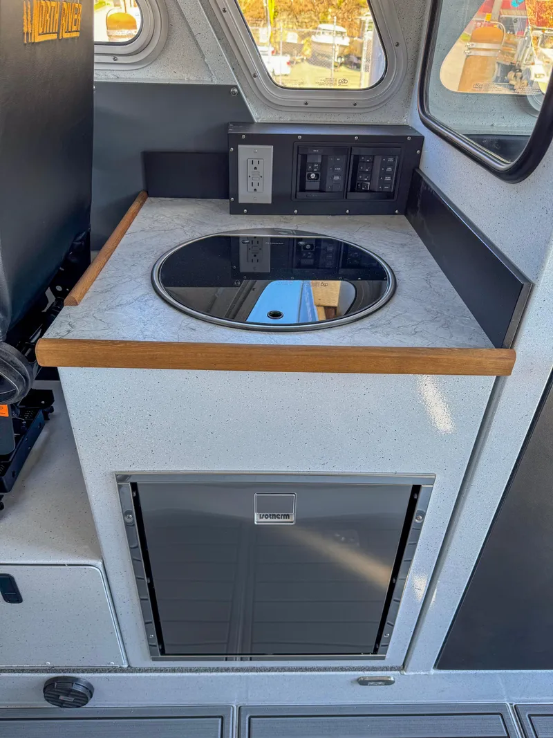 Slide: The Image of 2024 North River Seahawk OS 2700SXL boat interior with kitchenette and control panel. - 9