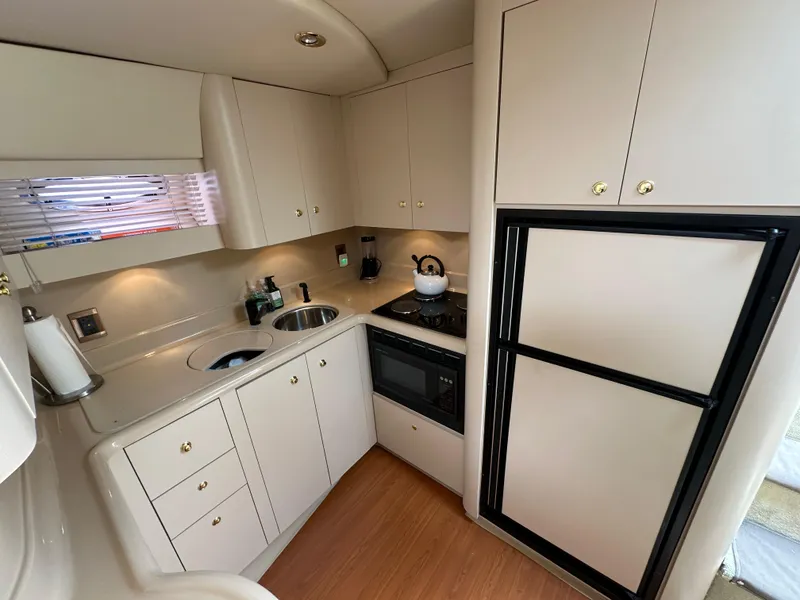 Slide: The Image of 1999 Cruisers Yachts 4270 Esprit kitchen with modern appliances and ample storage. - 13