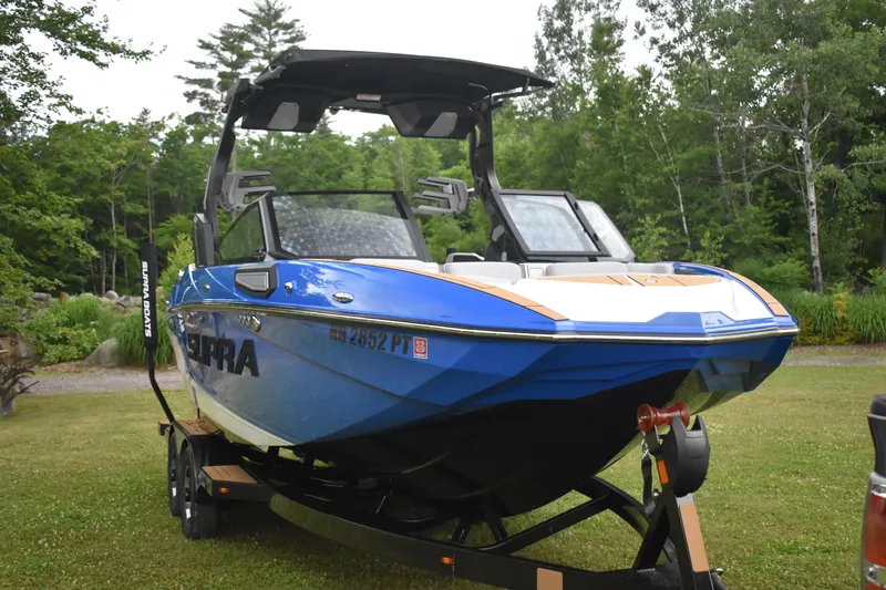 Slide: The Image of 2024 Supra SV boat on trailer in a lush green park. - 3