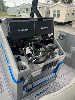 Slide: The Image of 2025 AMP 333CC boat dashboard with dual Garmin screens and steering wheel. - 9