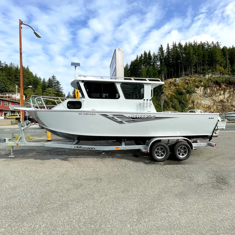 Slide: The Image of 2024 Hewescraft 240 Pacific Cruiser boat on a trailer in a scenic outdoor setting. - 0
