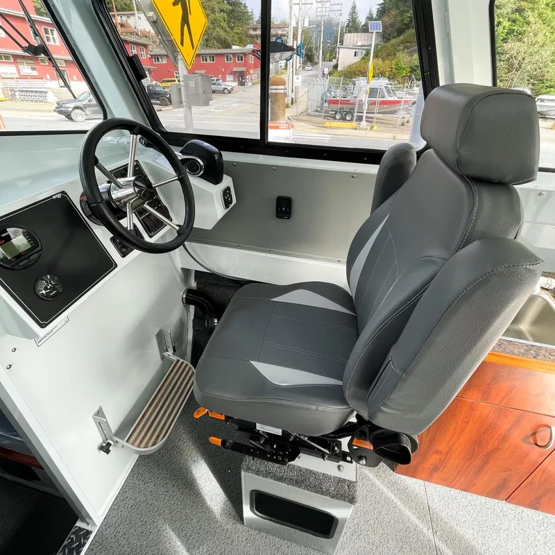 Slide: The Image of 2024 Hewescraft 240 Pacific Cruiser interior helm with captain's chair and steering wheel. - 4