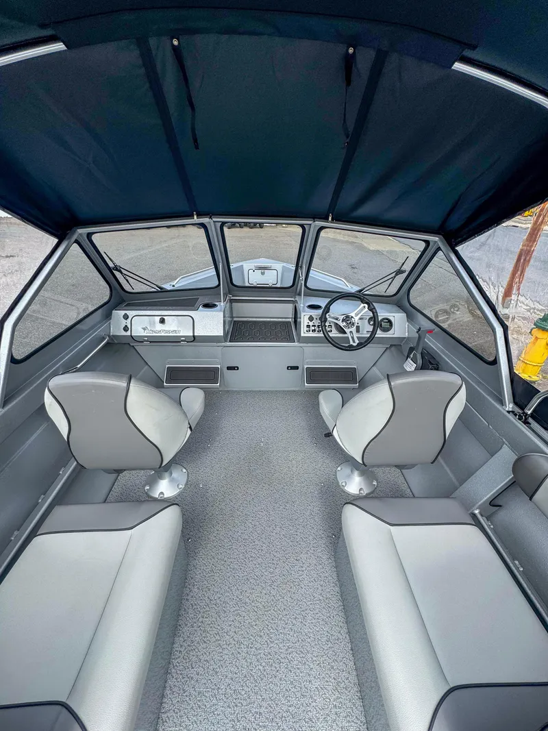 Slide: The Image of 2024 KingFisher 1825 Falcon boat interior with seating and steering console. - 2