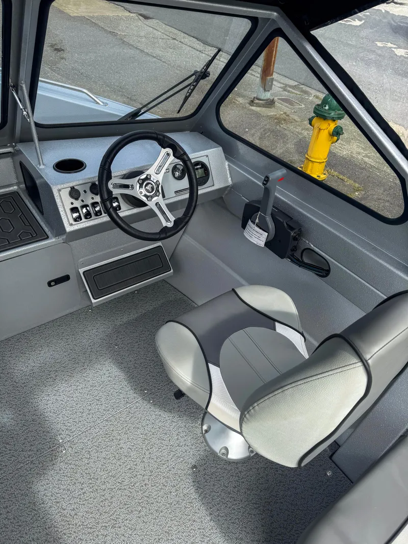 Slide: The Image of 2024 KingFisher 1825 Falcon boat interior with steering wheel and captain's chair. - 3