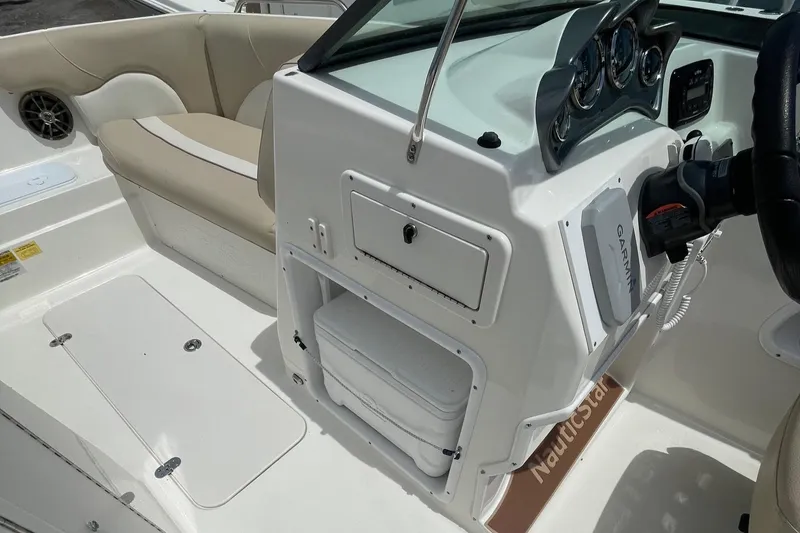 Slide: The Image of 2018 NauticStar 223DC Sport Deck boat interior with beige seating and control panel. - 12