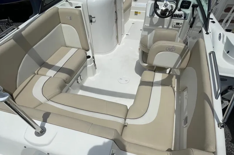 Slide: The Image of 2018 NauticStar 223DC Sport Deck boat interior with beige and white seating. - 13