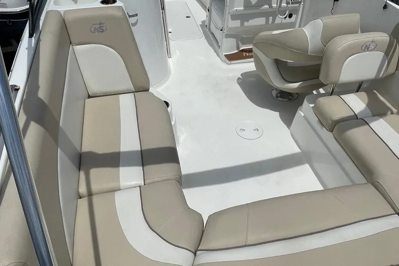 Slide: The Image of 2018 NauticStar 223DC Sport Deck boat interior with beige and white seating. - 14