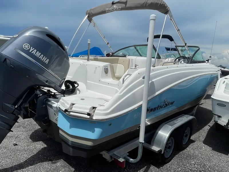 Slide: The Image of 2018 NauticStar 223DC Sport Deck boat with Yamaha outboard motor on trailer. - 2