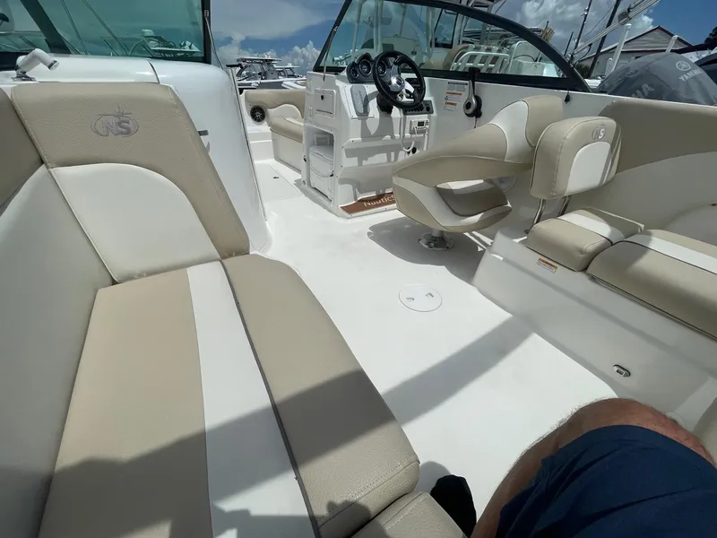 Slide: The Image of 2018 NauticStar 223DC Sport Deck interior with beige and white seating. - 8