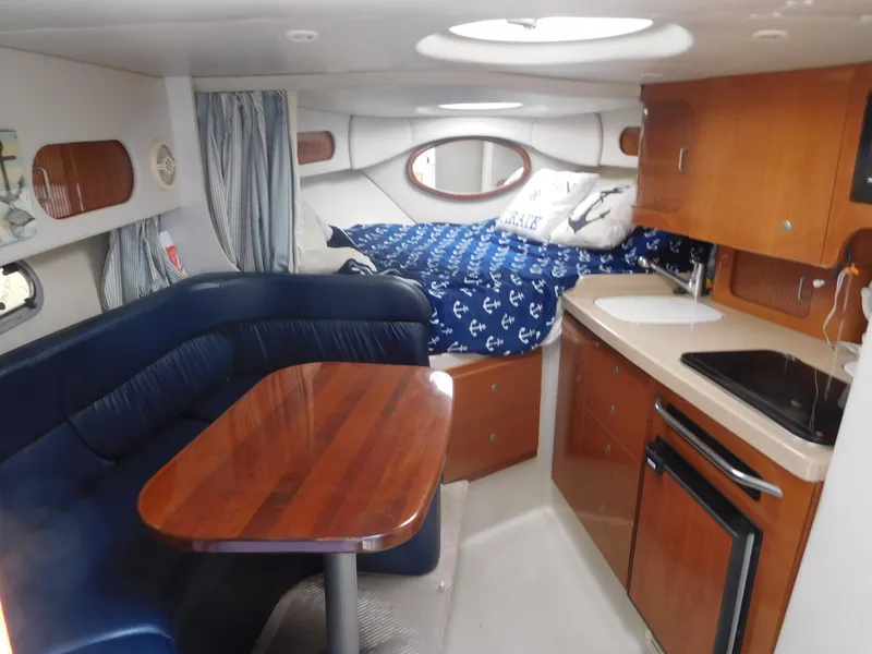 Slide: The Image of 2001 Four Winns 298 Vista cabin interior with kitchen, dining area, and bed. - 18