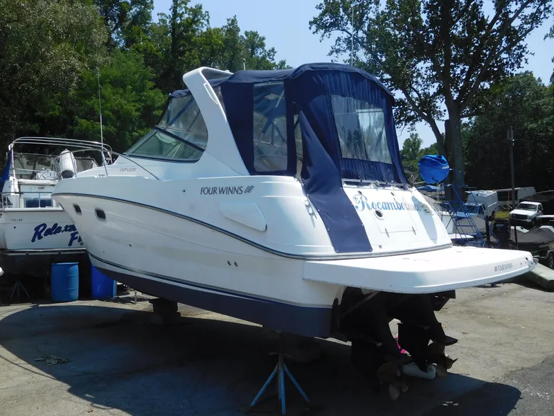 Slide: The Image of 2001 Four Winns 298 Vista boat on dry dock with blue canopy. - 2