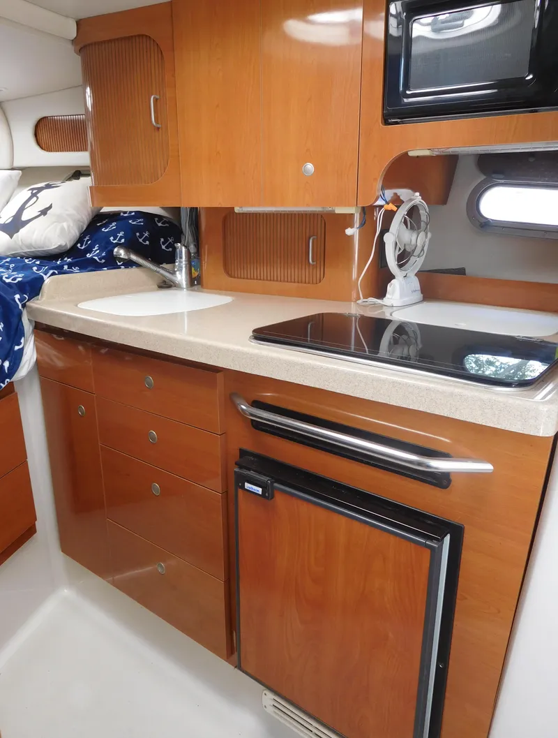 Slide: The Image of 2001 Four Winns 298 Vista boat interior kitchen with wooden cabinets and modern appliances. - 21