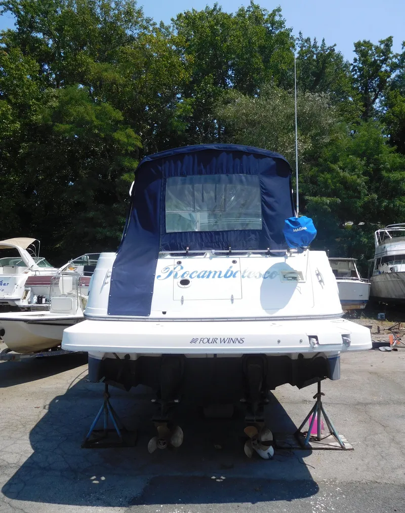 Slide: The Image of 2001 Four Winns 298 Vista boat on stands, rear view, with blue canopy. - 3
