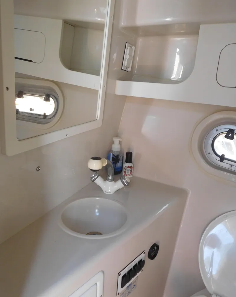 Slide: The Image of 2001 Four Winns 298 Vista boat bathroom with sink, mirror, and porthole windows. - 30