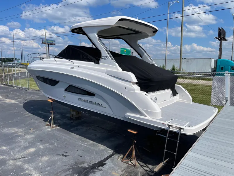 Slide: The Image of 2025 Regal 33 Express boat on stands, covered, dockside. - 1