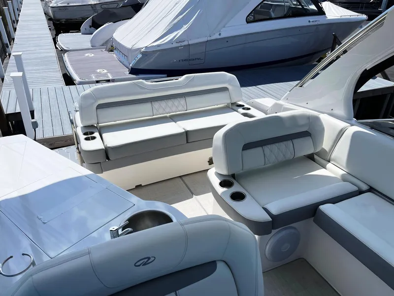 Slide: The Image of 2025 Regal 33 Express boat interior with white and gray seating at dock. - 5