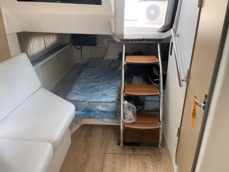Slide: The Image of Interior cabin of 2025 Regal 33 Express yacht with bed, stairs, and seating. - 9