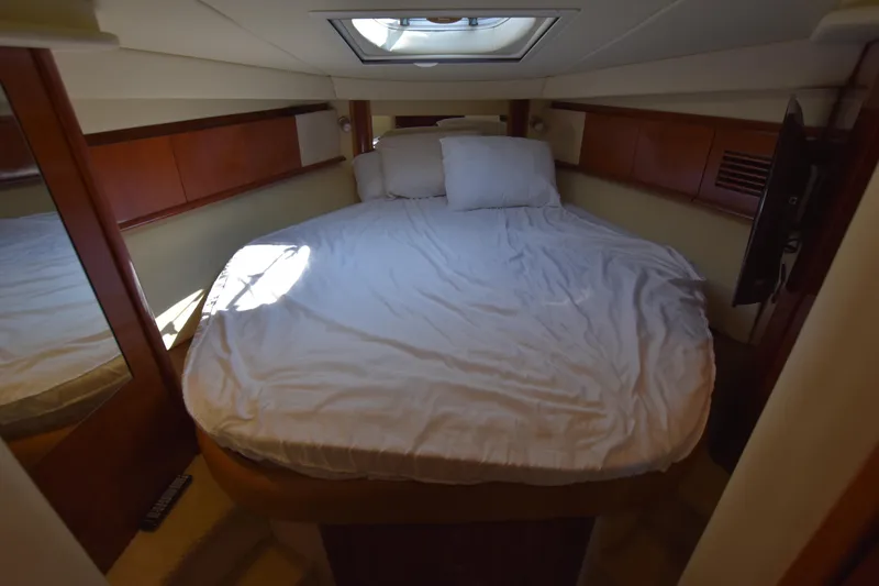 Slide: The Image of 2006 Sea Ray 40 Sundancer cabin with bed, skylight, and wooden accents. - 30
