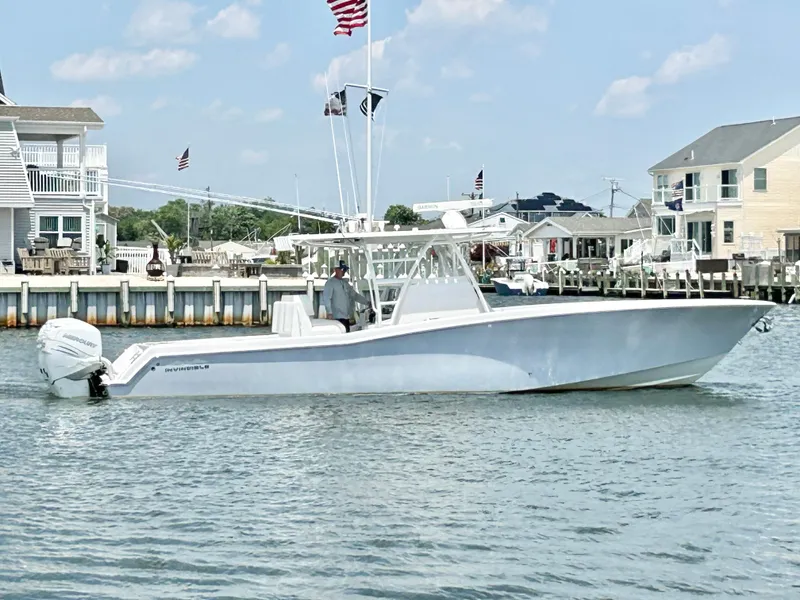 Slide: The Image of 2018 Invincible 36 Open boat cruising near waterfront homes. - 1