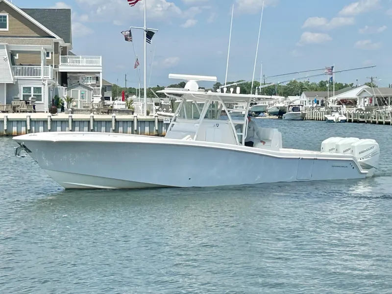 Slide: The Image of 2018 Invincible 36 Open boat cruising near waterfront homes. - 2