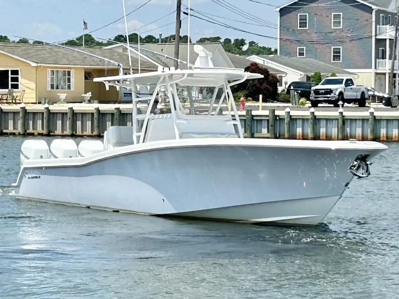 Slide: The Image of 2018 Invincible 36 Open boat cruising near a dock. - 3