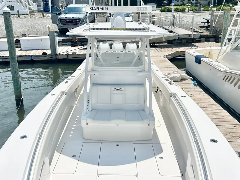 Slide: The Image of 2018 Invincible 36 Open boat docked at marina, featuring spacious deck and advanced Garmin navigation. - 8