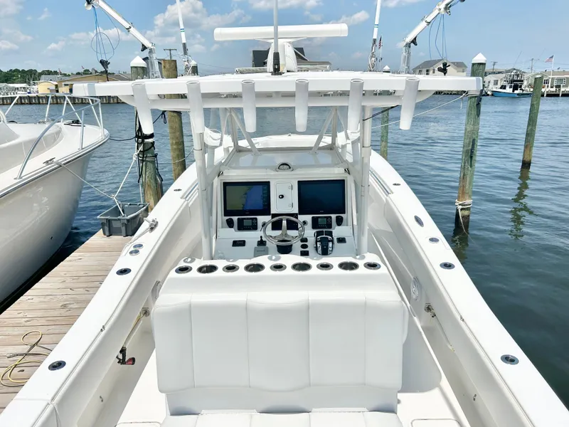 Slide: The Image of 2018 Invincible 36 Open boat docked at marina, view of helm and seating. - 9