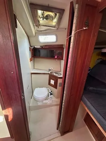 Slide: The Image of 1983 Catalina 30 Tall Rig sailboat interior bathroom with wooden cabinetry and compact design. - 11