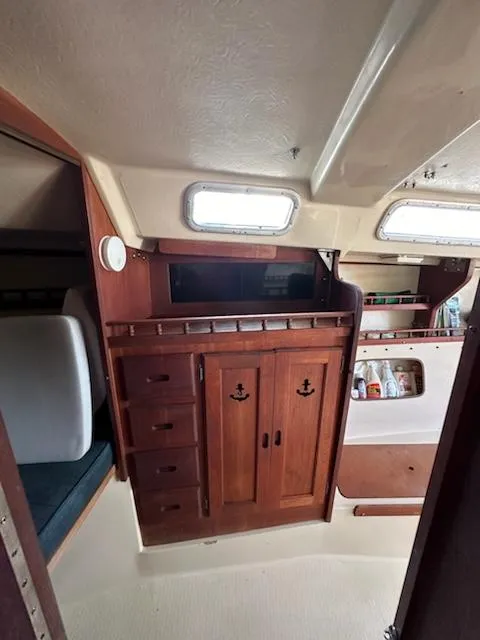 Slide: The Image of 1983 Catalina 30 Tall Rig interior with wooden cabinets and storage shelves. - 13