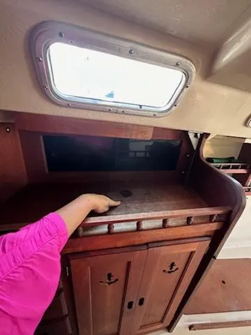 Slide: The Image of Interior of 1983 Catalina 30 Tall Rig sailboat with wooden cabinetry and porthole window. - 15