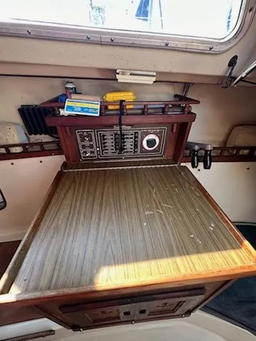 Slide: The Image of 1983 Catalina 30 Tall Rig navigation station with control panel and storage. - 18