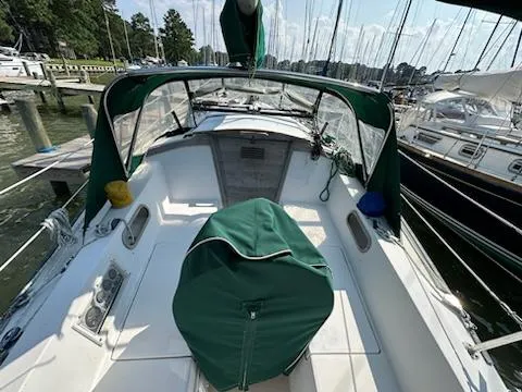 Slide: The Image of 1983 Catalina 30 Tall Rig sailboat with green covers docked at a marina. - 24