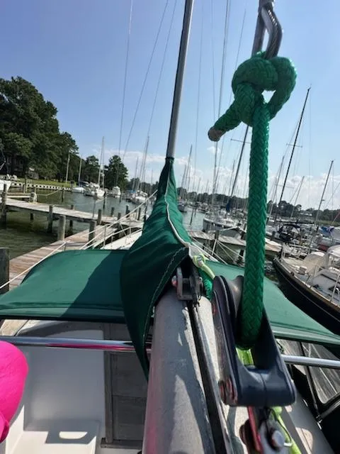 Slide: The Image of 1983 Catalina 30 Tall Rig sailboat docked, featuring green sail cover and marina background. - 27