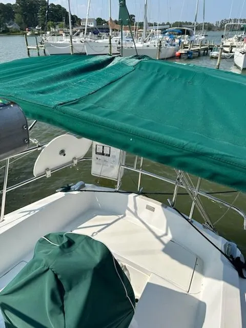 Slide: The Image of 1983 Catalina 30 Tall Rig sailboat with green canopy docked at marina. - 31